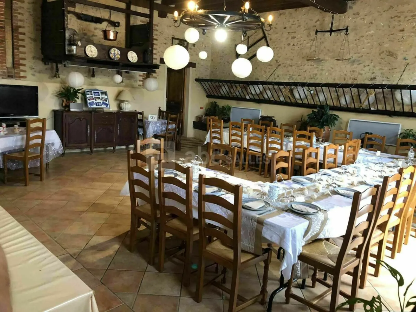 La Petite Etable, salle de réception intimiste avec grande tablée dressée à La Ferme Des Jallots
